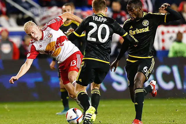 Mike Grella #13 of New York Red Bulls tries to get by Tony Tchani #6 of Columbus Crew during their match at Red Bull Arena on November 29, 2015